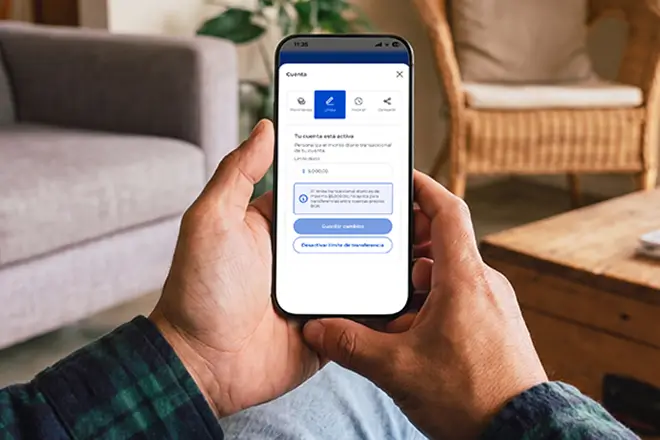 Hombre sosteniendo un celular configurando los límites de transferencias en BGR Digital
